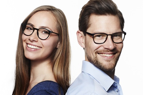Man and woman wearing glasses smiling