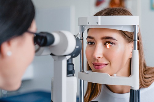 Woman's eye being examined by female doctor using equipment